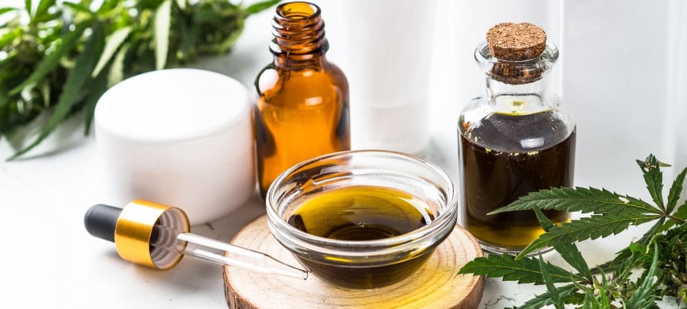 Gotero y recipientes con tipos de aceite de CBD de diferentes espectros y purezas.