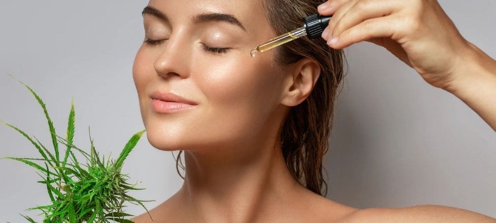 Aplicación de aceite de CBD en el rostro como parte de una rutina de cosmética natural