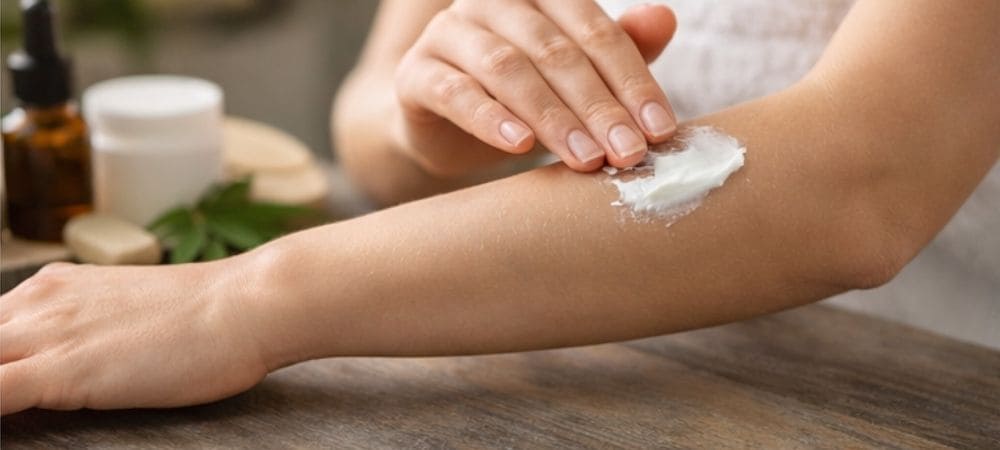 Aplicación de crema de CBD sobre la piel del brazo para cuidado corporal