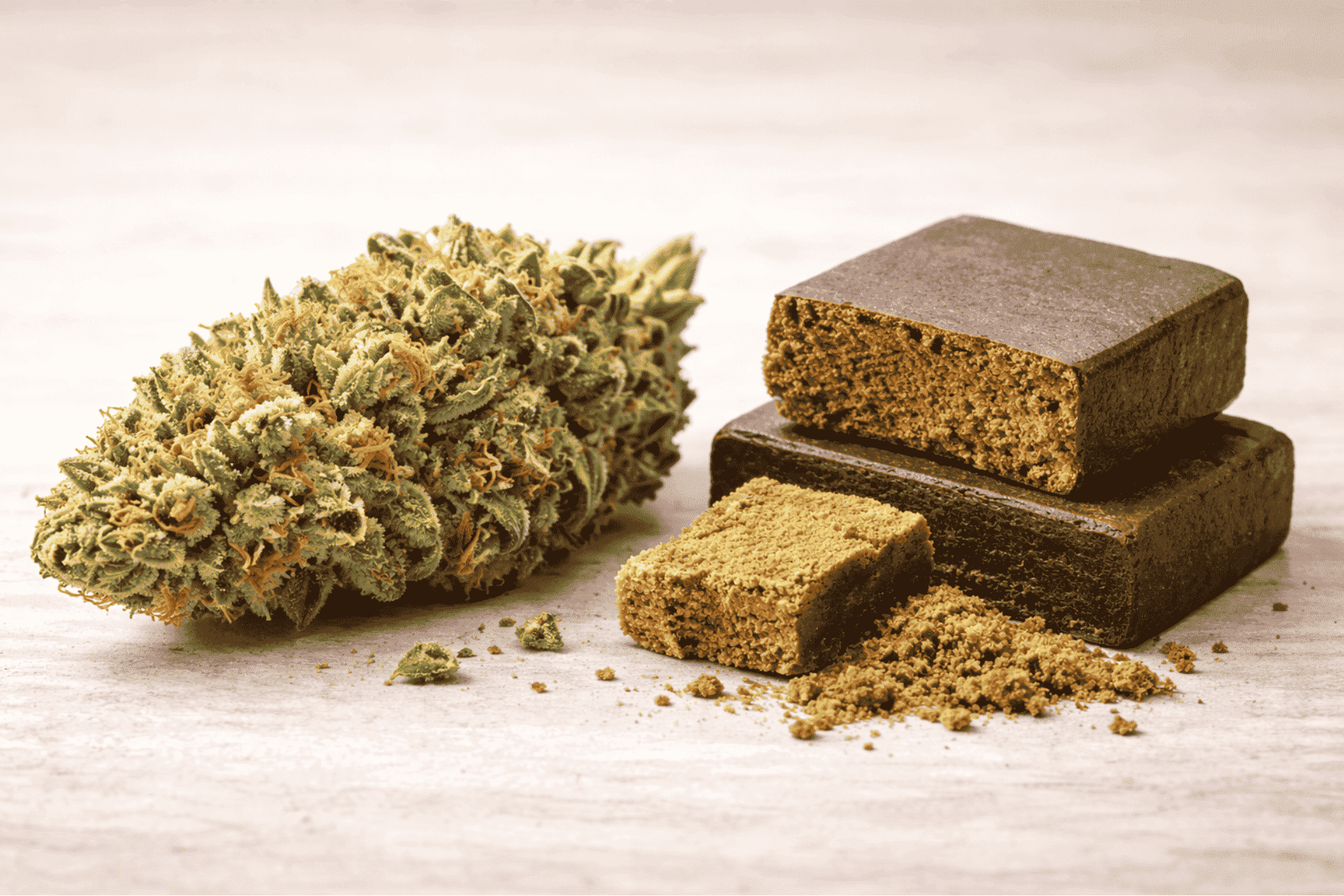 Flor de cannabis junto a bloques de hachís desmenuzado, imagen ilustrativa sobre qué es el hachís